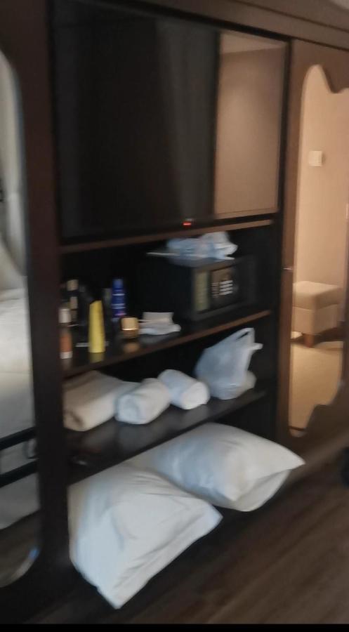 Buona Vitta Gramado Resort & Spa By Gramado Parks Екстер'єр фото The photo shows a piece of furniture, likely a shelving unit or cabinet, with several items on it. There is a television mounted on top. Below the TV, there is a microwave and a small safe. The shelves contain various toiletries and personal care pro