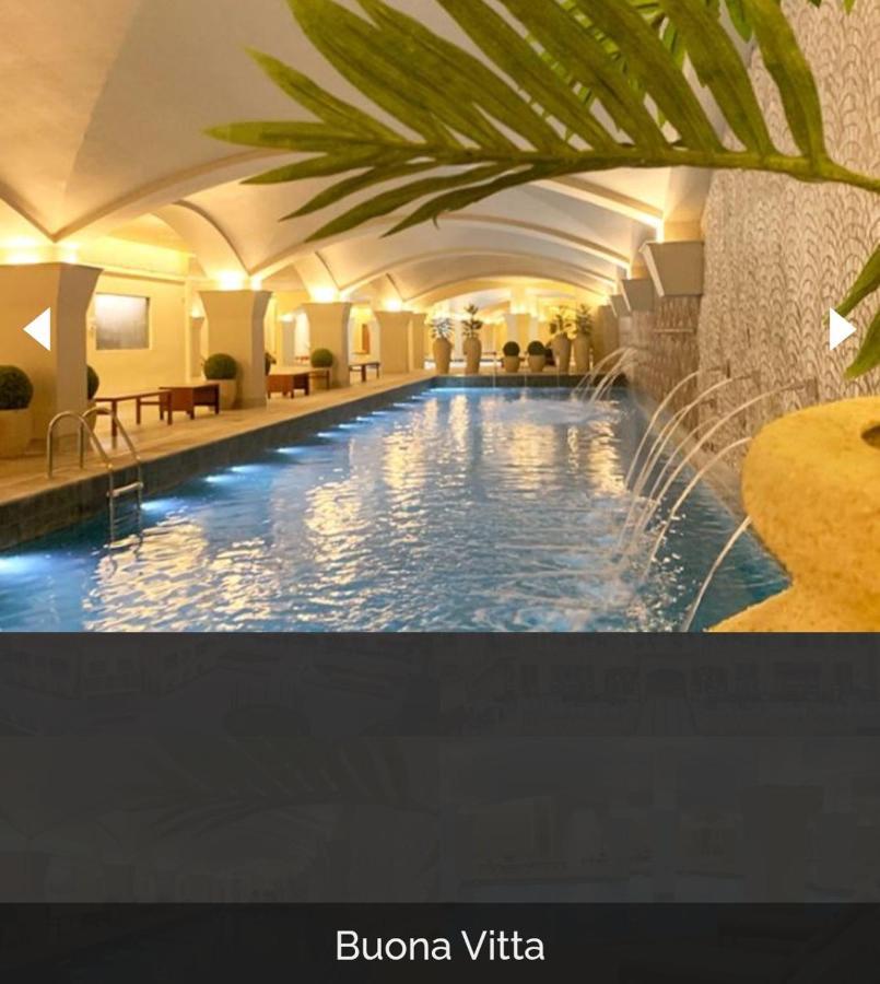 Buona Vitta Gramado Resort & Spa By Gramado Parks Екстер'єр фото The photo depicts an elegant indoor swimming pool area. The pool is illuminated with lights along its edge, and there are gentle water features creating a calming atmosphere. The ceiling has an arched design, and the space is decorated with plants an