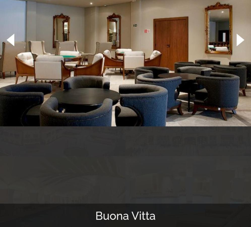 Buona Vitta Gramado Resort & Spa By Gramado Parks Екстер'єр фото The photo shows a modern, elegantly designed lounge or waiting area. It features several circular seating arrangements with dark blue armchairs surrounding black tables. In the background, there are light-colored lounge chairs and a wooden door leadi