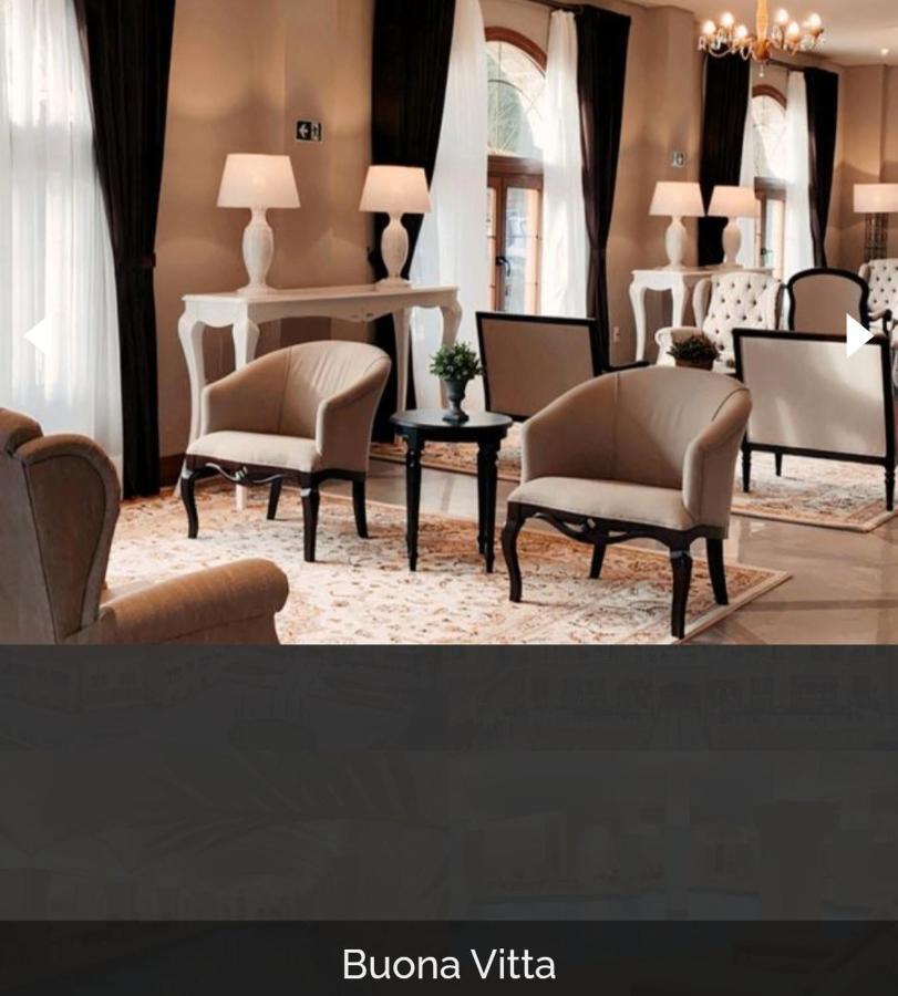 Buona Vitta Gramado Resort & Spa By Gramado Parks Екстер'єр фото The photo shows a stylish and inviting interior space, likely a lounge or waiting area. There are beige upholstered armchairs arranged around a small black table. A decorative plant is placed on the table. Behind the chairs are light-colored walls wi