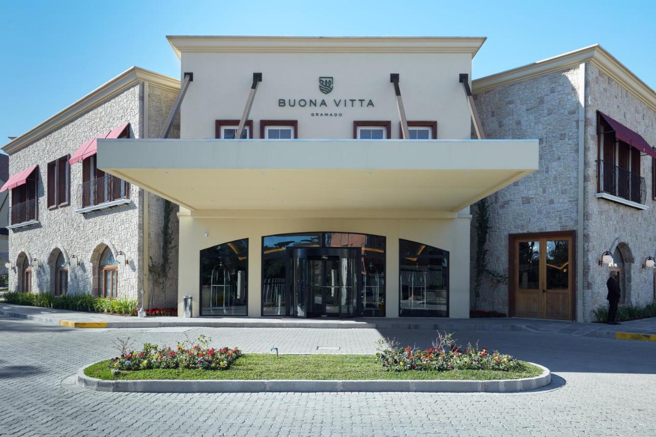 Buona Vitta Gramado Resort & Spa By Gramado Parks Екстер'єр фото The photo shows a modern building with a prominent entrance marked by a large awning. The facade features a mix of stone and stucco materials, giving it an elegant and contemporary look. The name "BUONA VITTA" is displayed prominently above the entra